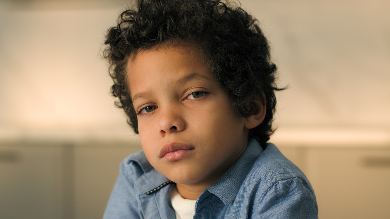 A young boy looks despondent.